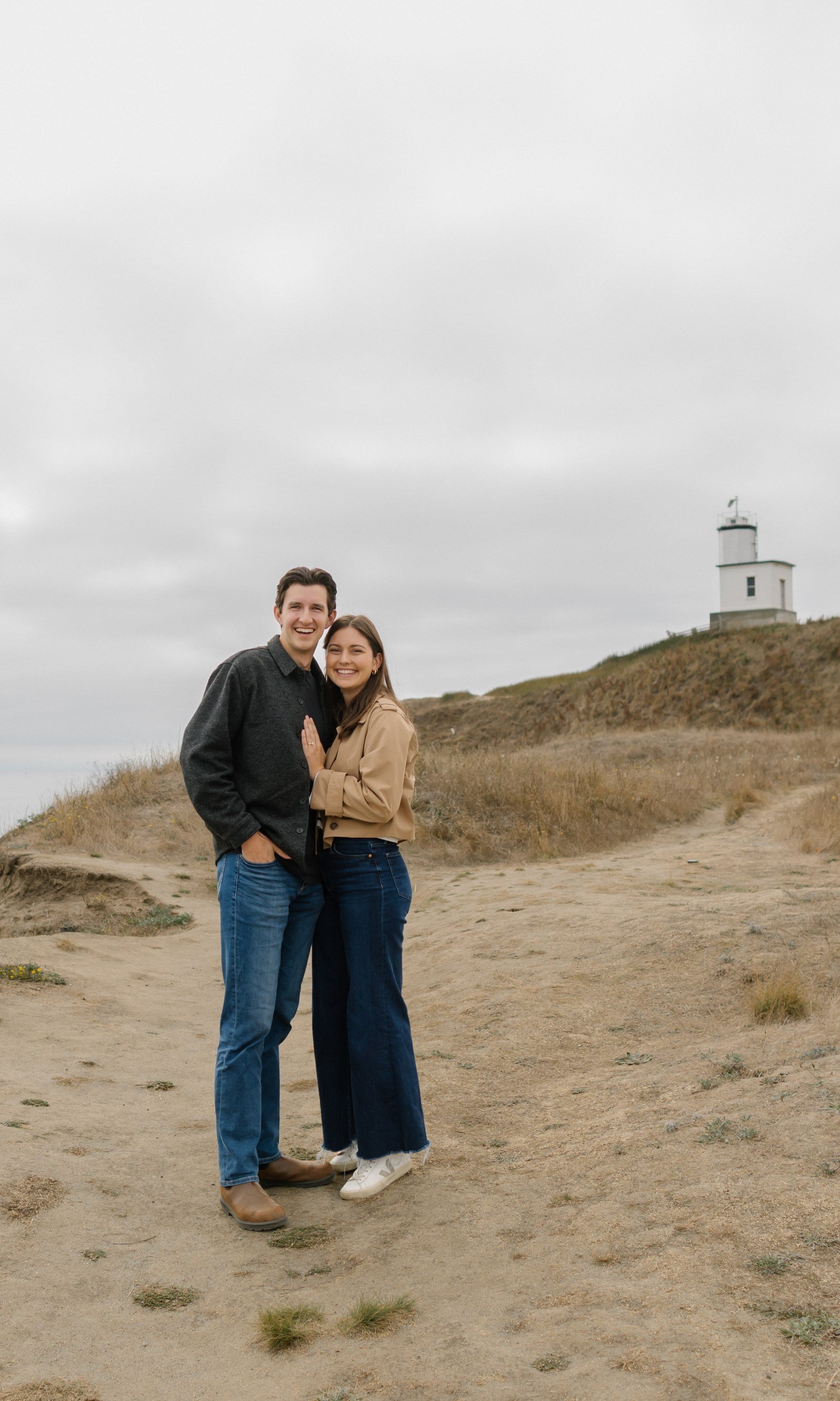 Ellie and Graham on the bluff at Cattle Point, with the lighthouse behind them